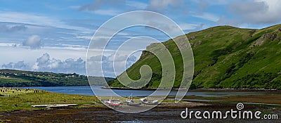 Colorful stranded fishing boats at low tide in Loch Harport on the picturesque west coast of the Isle of Skye Editorial Stock Photo