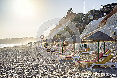 Colorful sun beds under straw umbrellas on the beach Editorial Stock Photo