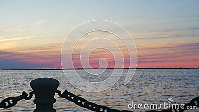 Colorful sunset over calm lake from pier Stock Photo