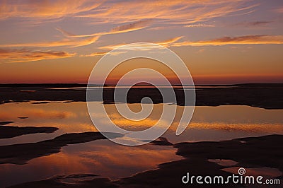 Reflected Sunset over tidal pools Stock Photo