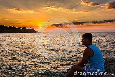 Colorful sunset in the sea and silhouette of traveler Stock Photo