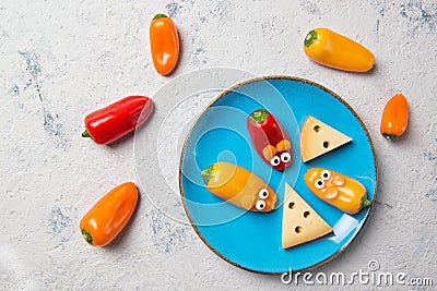 Colourful sweet mini peppers in the shape of mouses and pieces of cheese on a plate, stone table, top view, snack for kids idea Stock Photo