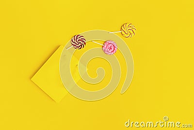 Colorful sweets candy lollypop out of yellow paper bag. Unhealthy food, concept Refusal of sweet Stock Photo