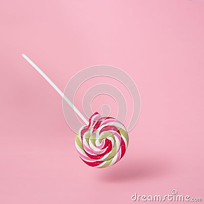 Colorful swirling lollipop on pink background. Stock Photo