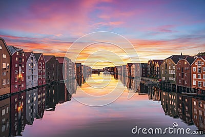 Colorful timber houses surrounding river Nidelva in the city of Trondheim at sunset.Norway Stock Photo