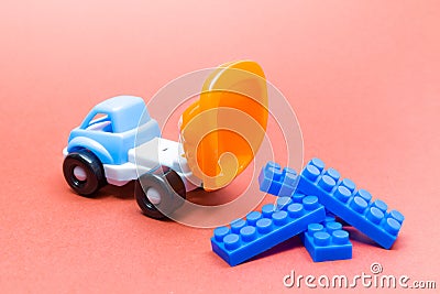 Colorful toy truck on a pink background and with constructor blocks Stock Photo