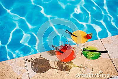 Colorful tropical cocktail with berries on edge of swimming pool Stock Photo