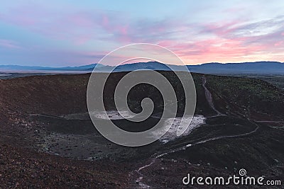 Colorful twilight above a cinder cone Amboy Crater in California Stock Photo