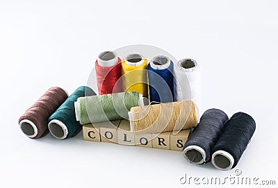 Colorful variety of threads and wooden cubes forming the word colors Stock Photo