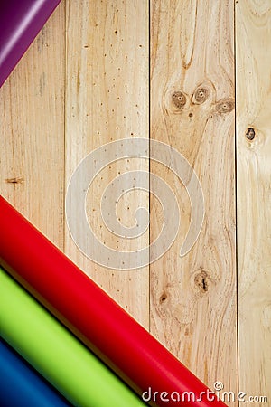 Colorful vinyl rolls on wooden background Stock Photo