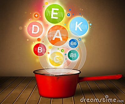 Colorful vitamins coming out from cooking pot Stock Photo