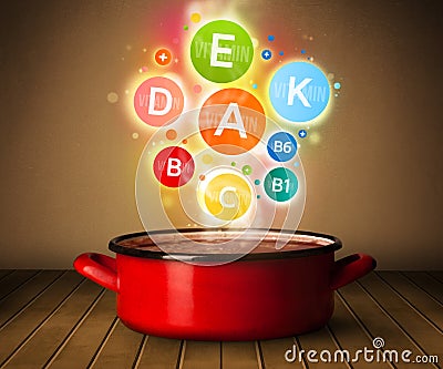 Colorful vitamins coming out from cooking pot Stock Photo