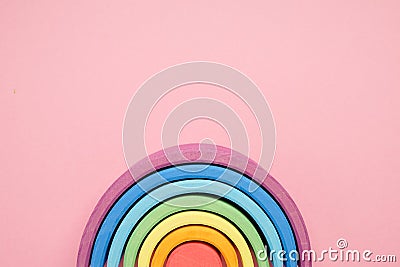 Colorful Waldorf wooden rainbow in a montessori teaching pedagogy on pink background Stock Photo