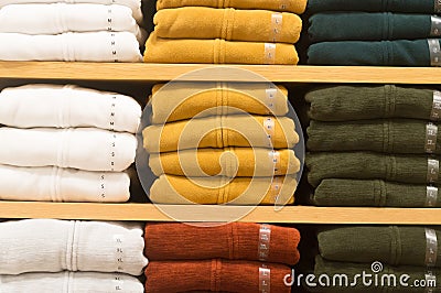 Colorful winter coats folded and orderly stacked on a shelf Stock Photo