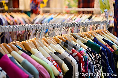 Colorful women`s dresses on hangers in a retail shop Stock Photo