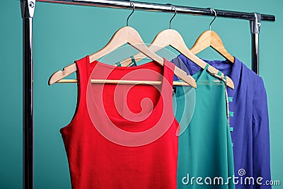 Colorful women`s shirts on wood hangers on blue background. RGB Stock Photo