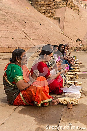 Colorful women sitting and praying at the ghats in Varanasi Editorial Stock Photo