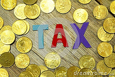 Colorful wooden alphabet with word TAX and coins. Tax concept. Stock Photo