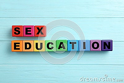 Colorful wooden blocks with phrase `SEX EDUCATION` on light blue background Stock Photo