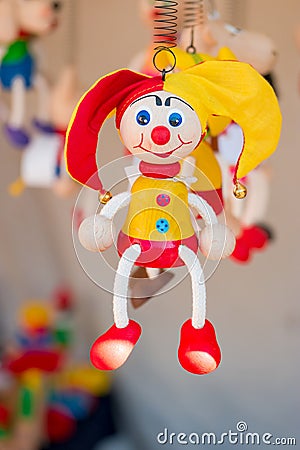 Colorful wooden buffoon figure hanging on the spring Stock Photo