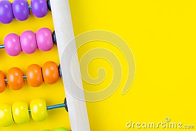 Colorful wooden pink and orange abacus beads on yellow background with copy space for presentation, business financial or account Stock Photo