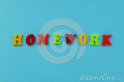 Colorful word `homework` of magnetic letters on blue paper background. Stock Photo