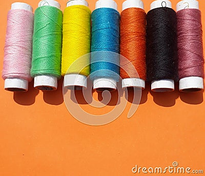 Colorful yarns on the orange background. Stock Photo