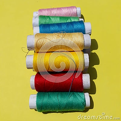 Colorful yarns on the yellow background. Stock Photo