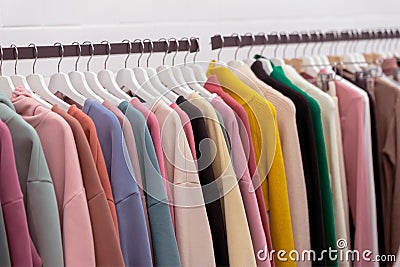 Colorful youth cashmere sweaters and hoodies, sweatshirts and on a clothes rack in store Stock Photo