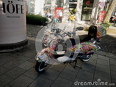 A colorfully designed white ladies scooter standing on roadside Editorial Stock Photo