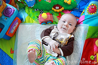 Colorfully dressed little boy playing on the floor Stock Photo