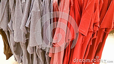 Colors of rainbow. Variety of casual shirts, t-shirts on hangers in a store. Cloth cotton of various bright colors close-up. Editorial Stock Photo