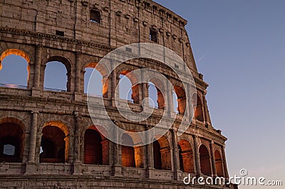 Colosseum, Rome, Italy. The outer wall of the evening coliseum. Arched openings are highlighted in orange backlighting. Stock Photo