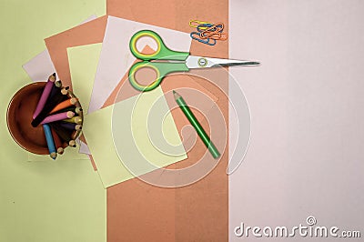 Colour paper, scissors, school stationery supplies, pencils, paint, and ruler lying on table. Origami DIY tutorial for kids Stock Photo