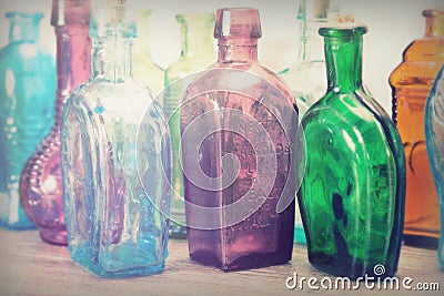 Coloured glass bottles on a rustic background Stock Photo