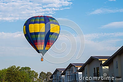 Colourful of balloon on blue sky with home village Stock Photo