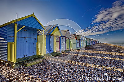 Colourful Beach Huts on the shingle at Hern Bay in Kent Stock Photo