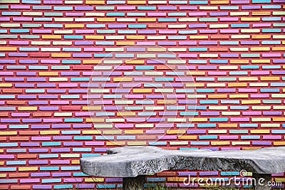 Colourful brick wall pattern background and texture with wooden bench Stock Photo