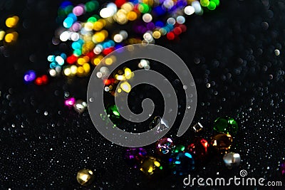 Colourful Christmas jingle bells. Black blurred bokeh background. Tilted. Stock Photo