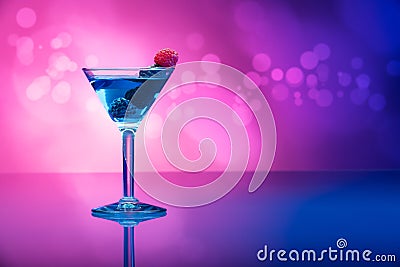 Colourful cocktails garnished with berries, background with light effects Stock Photo