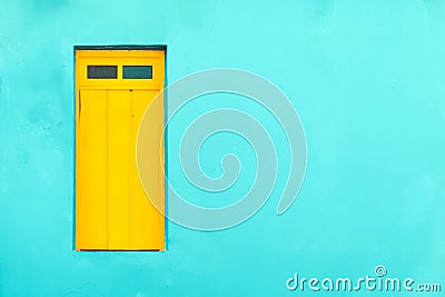 Colourful colonial Caribbean tropical style cyan facade with yellow closed window in a bright cyan wall house background Stock Photo