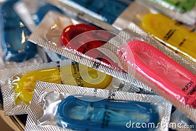 Colourful condoms in foil packets ready for use Stock Photo