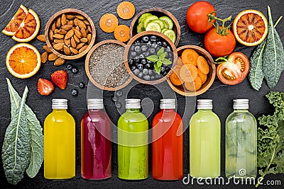 Colourful healthy smoothies and juices in bottles on dark stone background . Stock Photo