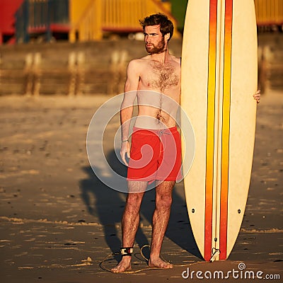 Colourful image of male surfer on beach with surfboard Stock Photo