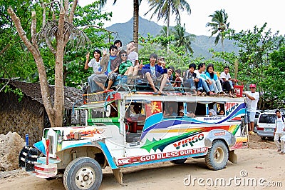 A colourful Jeepney taxi full of people on the roof prepares to leave the rural village Editorial Stock Photo