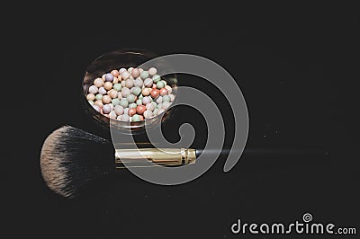 Beauty powder balls and brush on black background Stock Photo