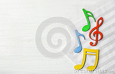 Colourful musical notes lying on music sheets Stock Photo