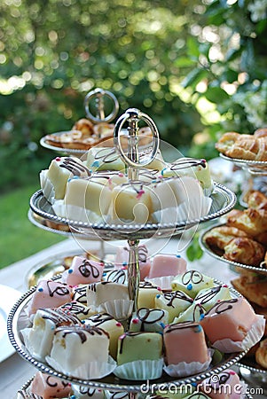 Colourful petit fours on a cake stand with bokeh Stock Photo