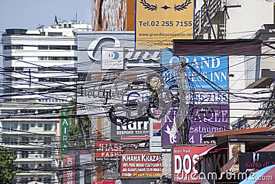 Colourful signboards for advertising hang on the buidling along Sukhumvit district of central Bangkok Editorial Stock Photo