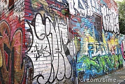 Colourful street art by an unknown artist on the wall of a building in a Fitzroy alley Editorial Stock Photo